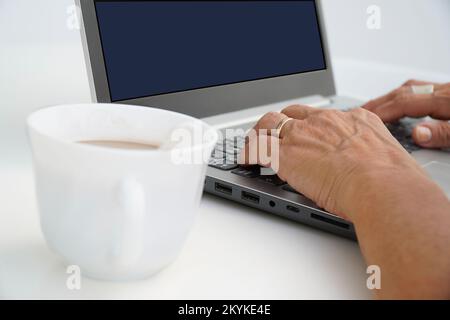unrecognizable business woman working on the computer with a coffee. freelance digital nomad Stock Photo