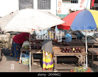 Two women arranging avocadoes and aubergines for sale at the local market, Stock Photo