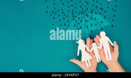 Umbrella protects family from difficult problems, help and support, social issue, insurance business Stock Photo