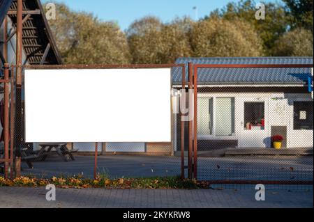 Blank white advert banner with mockup space on metal fence Stock Photo