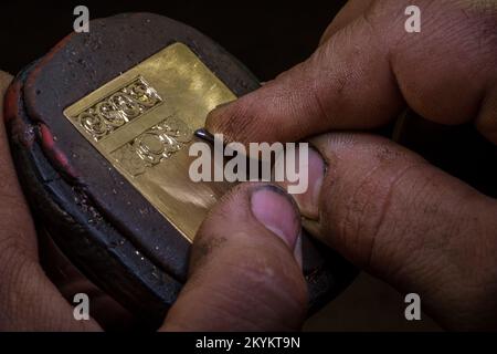 Close-up of engravers hands engraving on gold watch blank, handmade watch production order, watch custom order, selective focus Stock Photo