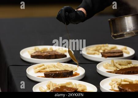 chef is serving pasticada with gnocchi, beef stew in a sauce. Croatian cuisine Stock Photo