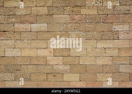 Shell limestone wall texture background with copy space. Yellow limestone, shell rock brick wall. Coquina rock, limestone brick wall background. Stock Photo
