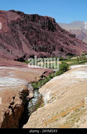 Red, magenta mountain scenery in the Kalu Valley near Bamyan (Bamiyan), Afghanistan. Taken on the southern route between the two cities. Stock Photo