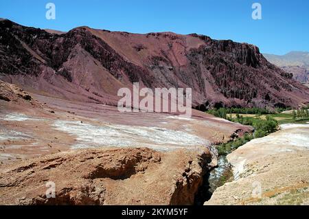 Red, magenta mountain scenery in the Kalu Valley near Bamyan (Bamiyan), Afghanistan. Taken on the southern route between the two cities. Stock Photo