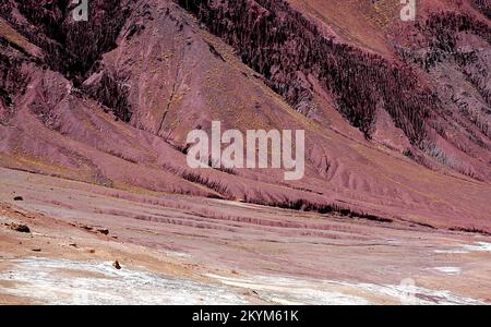 Red, magenta mountain scenery in the Kalu Valley near Bamyan (Bamiyan), Afghanistan. Taken on the southern route between the two cities. Stock Photo