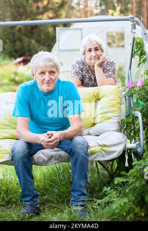 Portrait of a man and woman relaxing in a garden Stock Photo