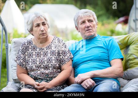 Elderly parents hear bad news, worried faces of Caucasian people Stock Photo