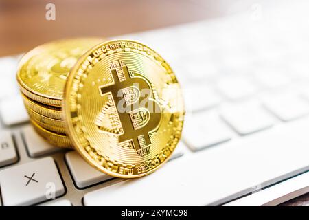 Cryptocurrency. Bitcoin virtual money. Gold coins laying on the computer keyboard. Stock Photo