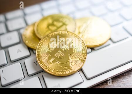 Cryptocurrency. Bitcoin virtual money. Gold coins laying on the computer keyboard. Stock Photo