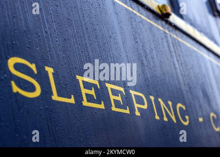 01 December 2022, Mecklenburg-Western Pomerania, Gadebusch: Raindrops can be seen on the sleeping car from the legendary Orient Express built in 1941 with the inscription 'Sleeping'. The wagon stands on the museum track next to the historic station. Once used between Paris and Istanbul, the 54-ton wagon was lifted by two truck-mounted cranes from the Deutsche Bahn operating track into the museum area during the night. Photo: Jens Büttner/dpa Stock Photo