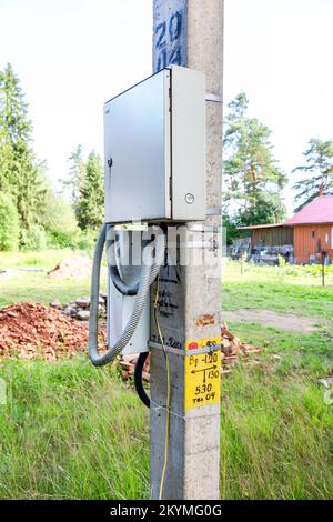 Electrical distribution board on a power line support in summer. Electrical junction box on the post Stock Photo
