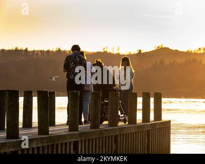 A family on a jetty on Lake Windermere, Ambleside, Lake District, UK. Stock Photo