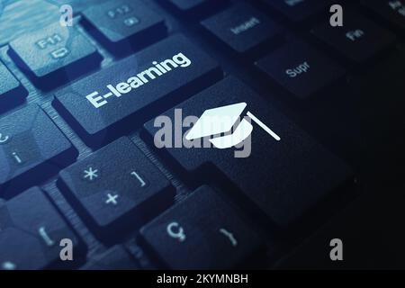 Black keyboard with E-learning word on button and graduation cap. Webinar. Online education. Distance courses. Stock Photo
