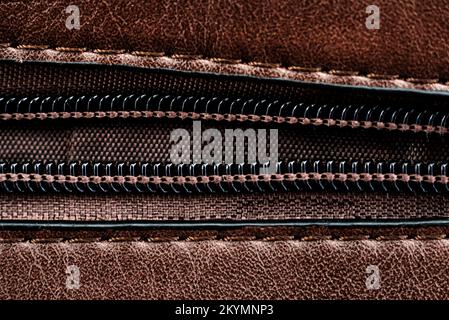 Zip closure on a brown leather bag. Texture with a lock with a zipper Stock Photo