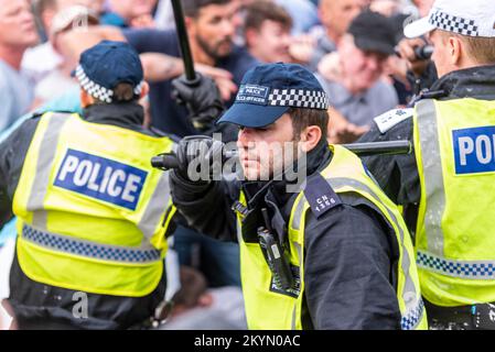 Supporters of Tommy Robinson such as the EDL protested in London demonstrating for his release after arrest. Injured police officer with bloodied nose Stock Photo