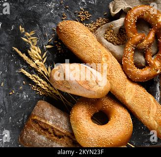 Baked bread assortment on black board background. Stock Photo