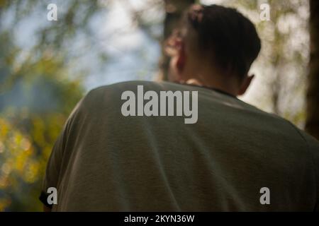 Back guy. Man in park. Close-up jacket. Stock Photo