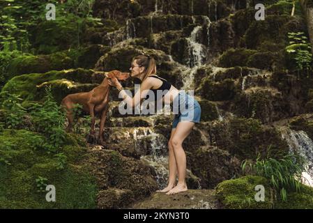 Woman with Dog in Nature by Mountain River Waterfall Stock Photo