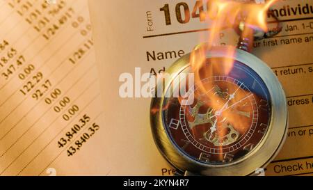 Burning pocket watch on financial papers as background Stock Photo