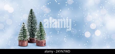 Mini Christmas trees on snow design background. Stock Photo