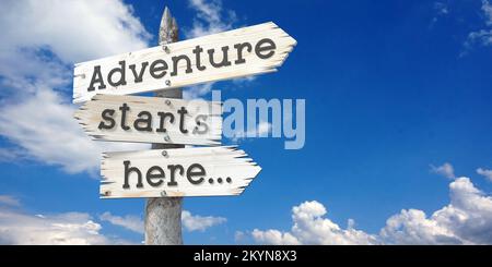 Adventure starts here - wooden signpost with three arrows Stock Photo