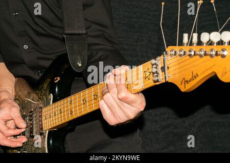 Vaduz, Liechtenstein, January 12, 2022 Artist is playing with a Fender Stratocaster Richie Sambora signature electric guitar painted in black paisley Stock Photo