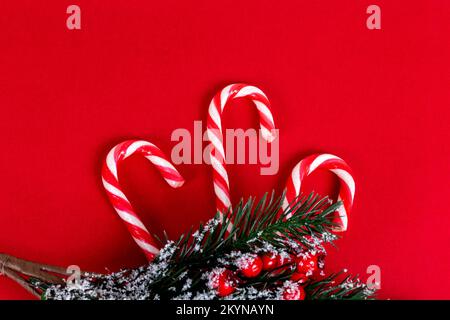 Candy cane with christmas tree on red background top view with copy space Stock Photo