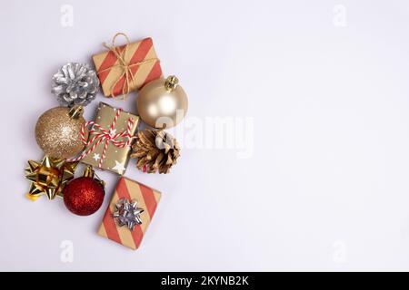 Christmas background with copy space on white, gift boxes, red and golden balls and pine cones top view. Template for postcards, banners, greeting Stock Photo