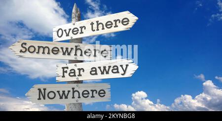 Over there, somewhere, far away, nowhere - wooden signpost with four arrows Stock Photo
