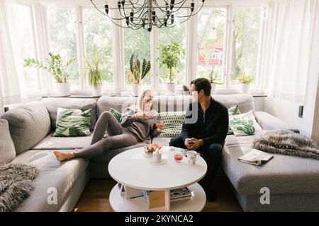 Happy couple having juice while spending leisure time at home Stock Photo