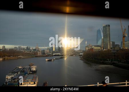 Seen from the top deck of a London bus that is driving over the river Thames on Waterloo Bridge, are the tall towers of the City of London - including the dome of St Paul's Cathedral - and on the right, the Southbank, all seen in late afternoon autumn sunlight, on 1st December 2022, in London, England. Stock Photo