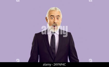 Surprised elderly gray-haired business man 60s in classic suit keeping mouth open say wow Stock Photo
