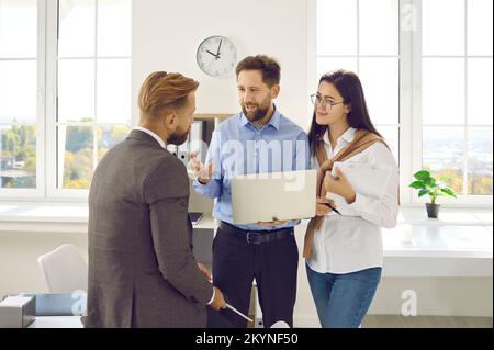 Joyful and inspired colleagues in office together discussing new business idea and its project. Stock Photo