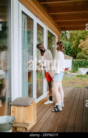 Happy couple talking to each other while entering in house Stock Photo