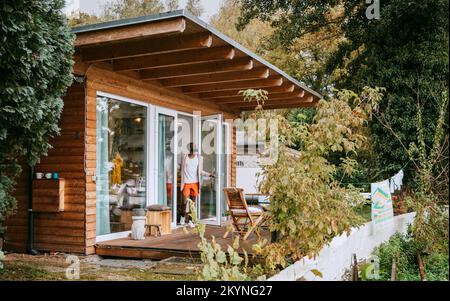 Mature man standing at doorway of tiny house Stock Photo