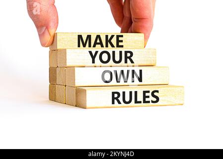 Make your own rules symbol. Concept words Make your own rules on wooden cubes. Beautiful white table white background. Businessman hand. Business moti Stock Photo