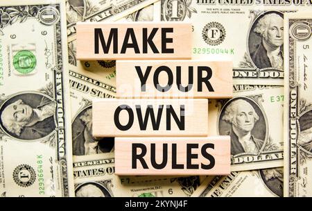 Make your own rules symbol. Concept words Make your own rules on wooden cubes. Beautiful background from dollar bills. Business motivational make your Stock Photo