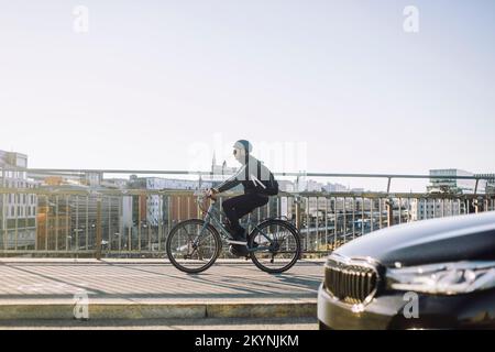 Full length side view of businessman riding bicycle on cycle lane Stock Photo