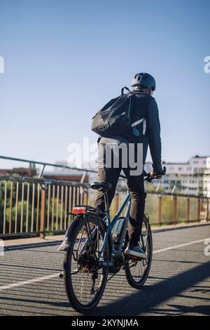 Businessman riding bicycle on lane while commuting to work Stock Photo