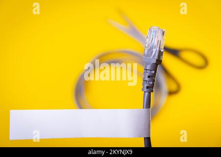 Internet cable and scissors cut it. Disconnection of Internet network. Connection to World Wide Web.. Stock Photo