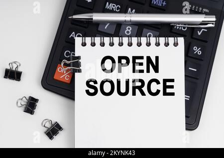 Business and economics concept. On the table is a calculator, a pen and a notebook with the inscription - OPEN SOURCE Stock Photo
