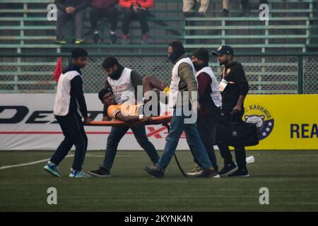 Paramedics carry a stretcher for an injured player onto the pitch ...