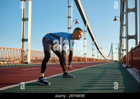 Fitness runner doing warm-up routine before running Stock Photo