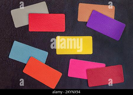 Abstract background of colorful multicolored genuine leather samples on dark leather Stock Photo