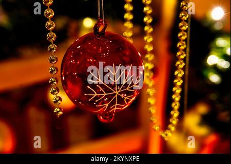 Christmas decoration with golden and red colored objects in front of a blurred background. Stock Photo