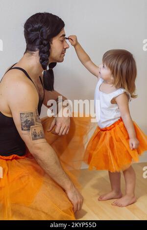 Father and little girl are wearing matching ballerina dresses.  Stock Photo