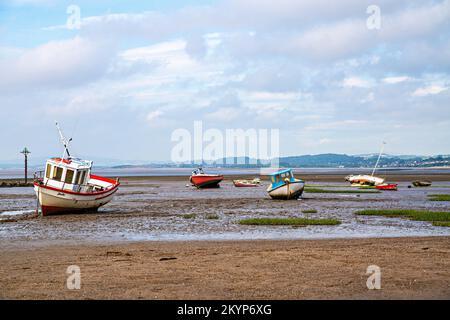 Small boats in Morecambe Bay at low tide Stock Photo