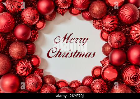 Christmas greeting card of red ball ornaments in a circle, Merry Christmas text Stock Photo