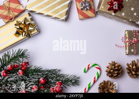 Christmas background frame with copy space on white, decoration elements with striped gift boxes candy canes, green fir tree branch and pine cones Stock Photo
